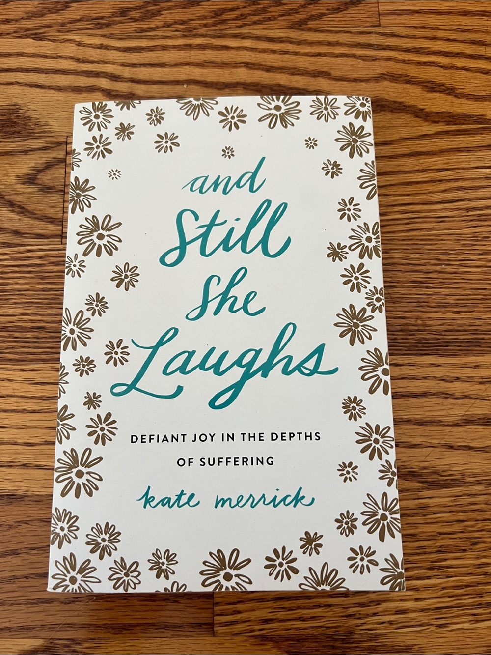 And Still She Laughs by Kate Merrick - White & Teal Floral Cover